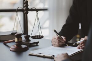 A Cincinnati criminal defense lawyer reviewing documents at a desk with a gavel and scales of justice in the background.