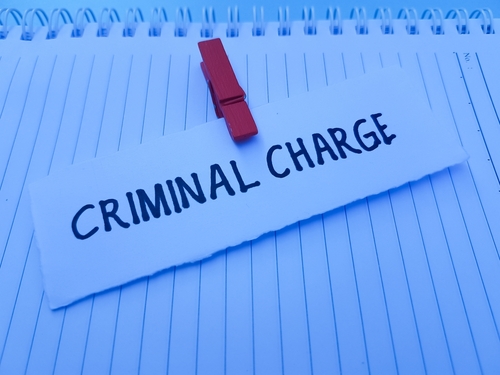 A note clipped with the words “Criminal Charge” written on it, symbolizing cases handled with the support of a Cincinnati criminal defense lawyer.